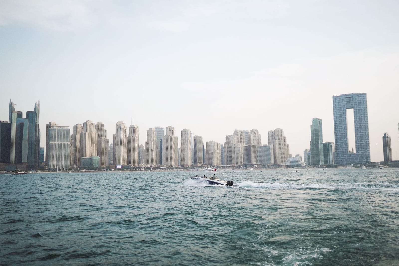 Скоростная лодка у JBR на фоне силуэта Дубай Марины